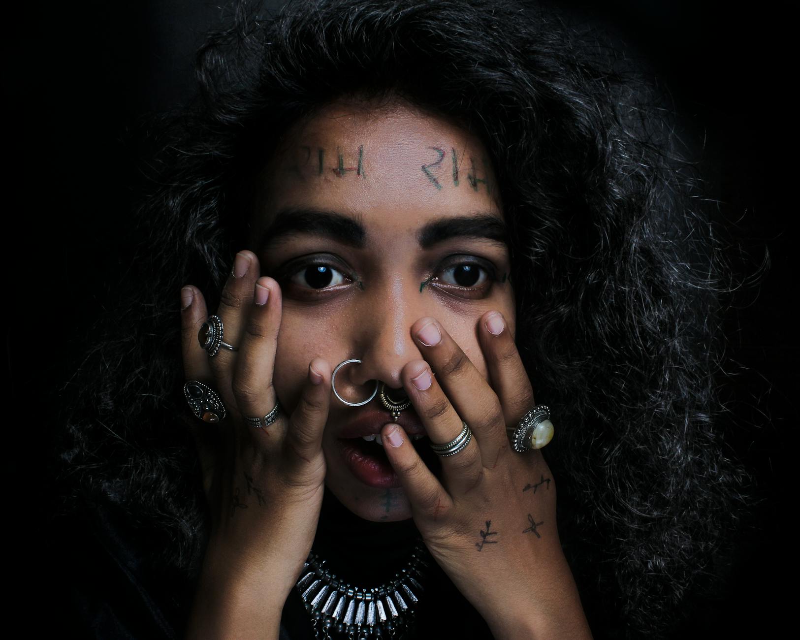 Kobieta z kolczykiem w nosie i pierścionkami, z wyrazistym spojrzeniem