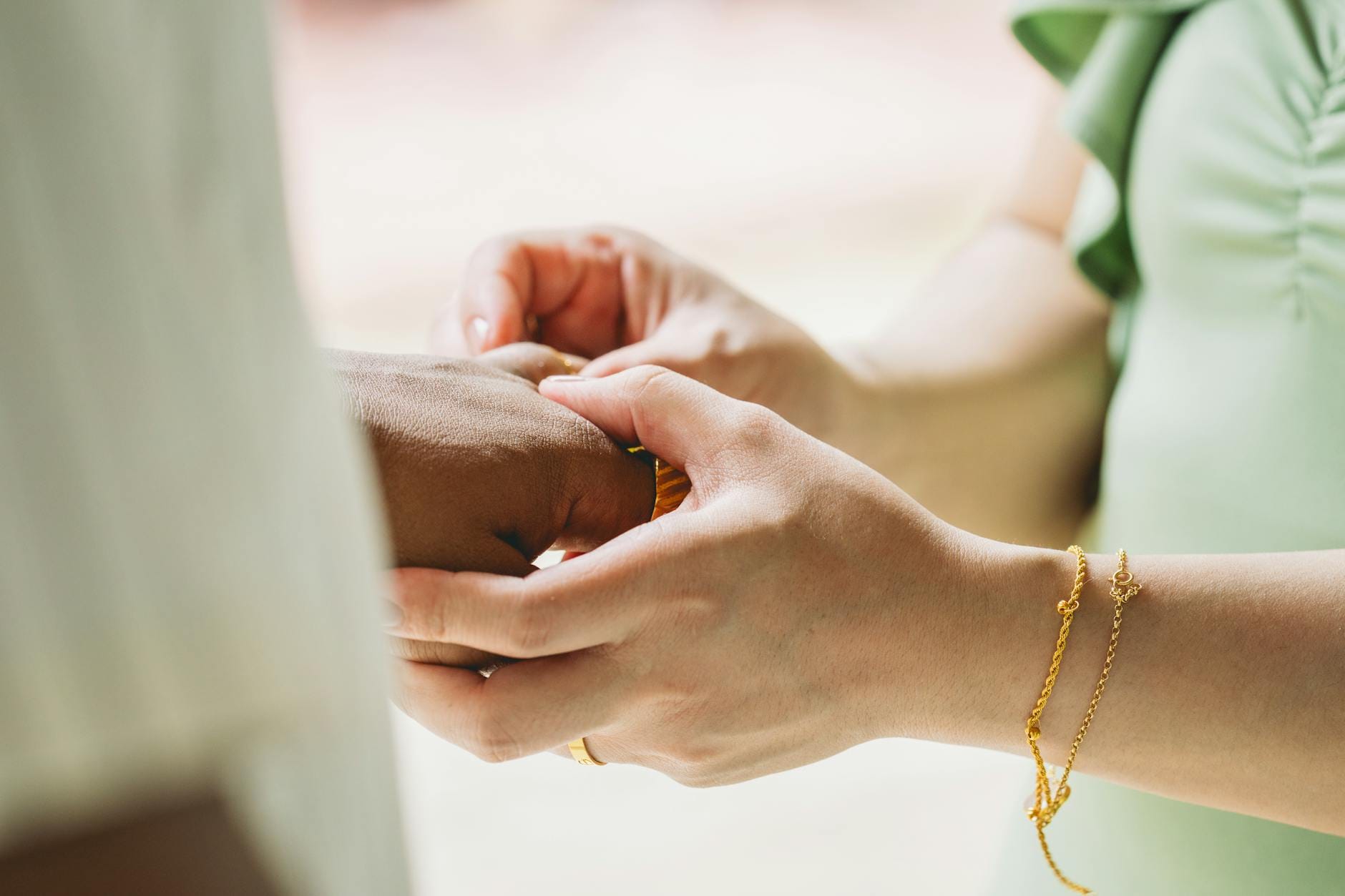 Para zakładająca sobie nawzajem złote obrączki na palec