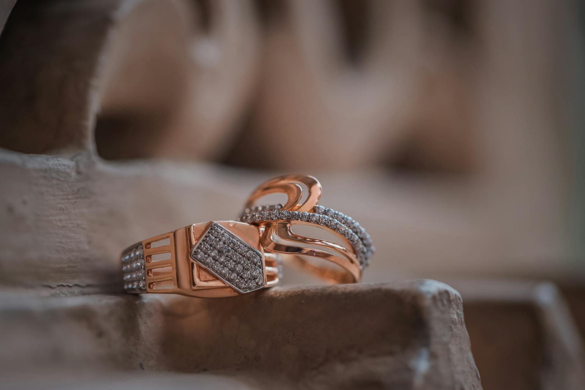 Zbliżenie złotych pierścionków z diamentami na fakturowanym tle