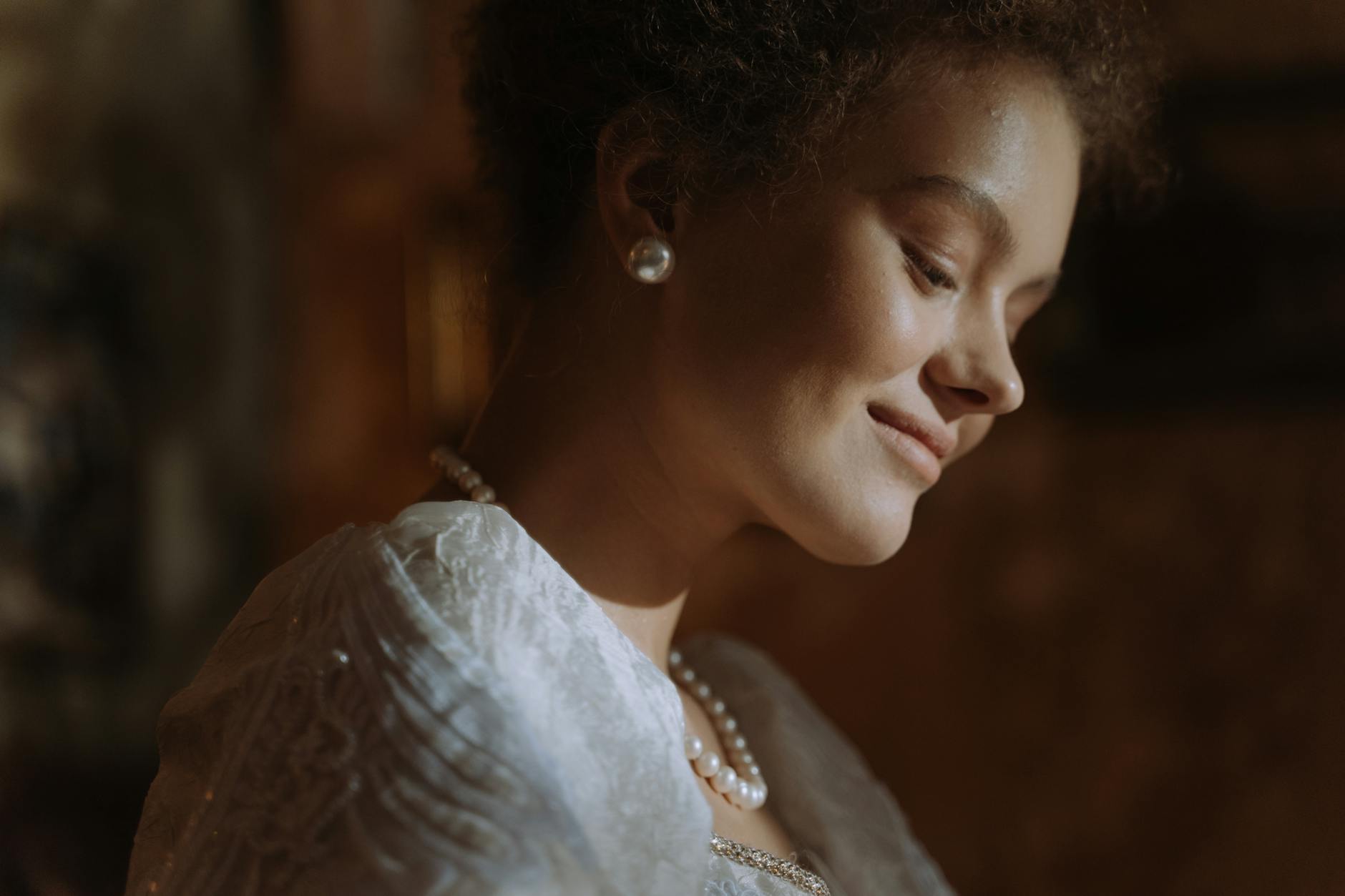 Elegancka kobieta w perłach uśmiecha się delikatnie