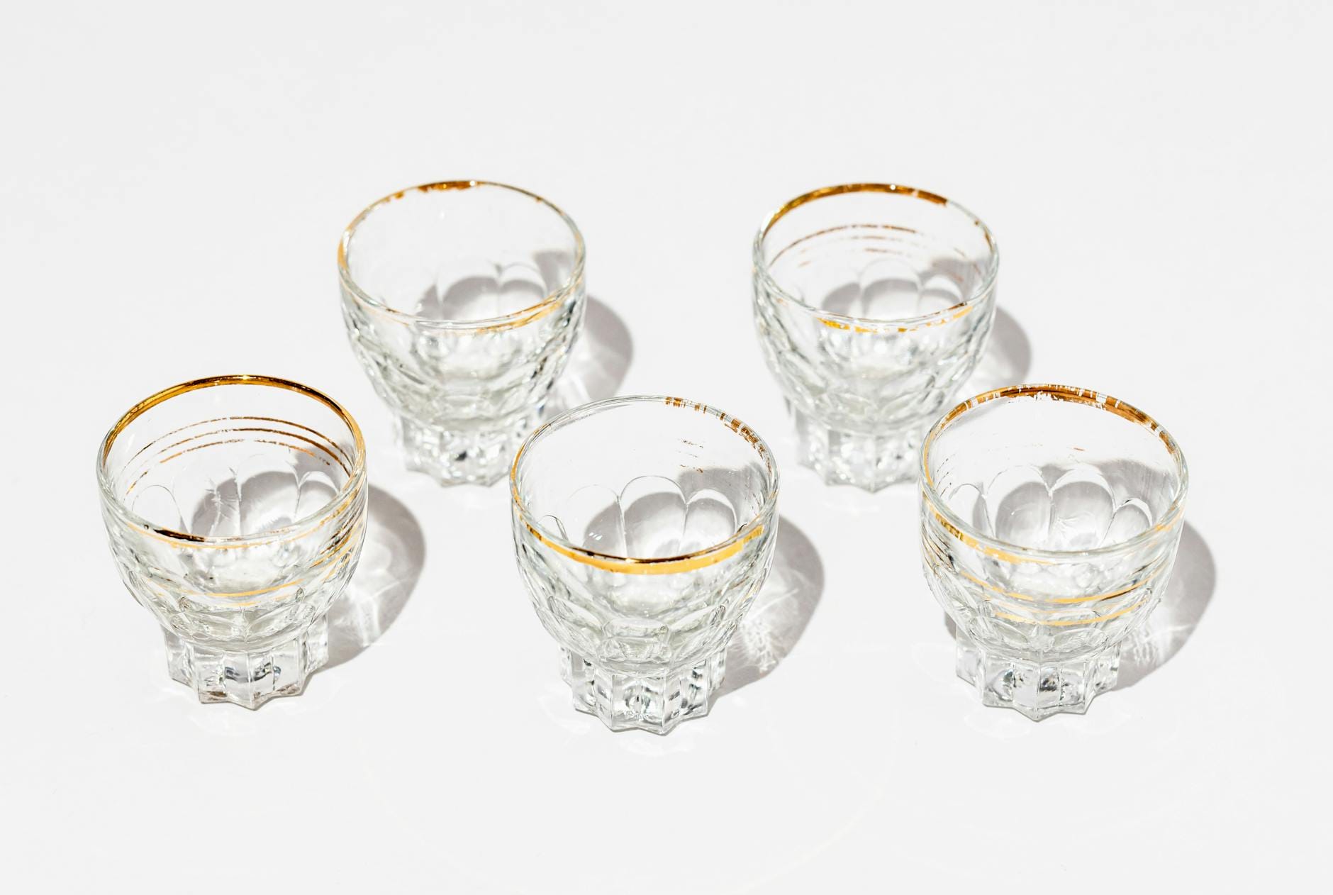 Eleganckie kieliszki z kryształu ze złotym rantem na białym tle
