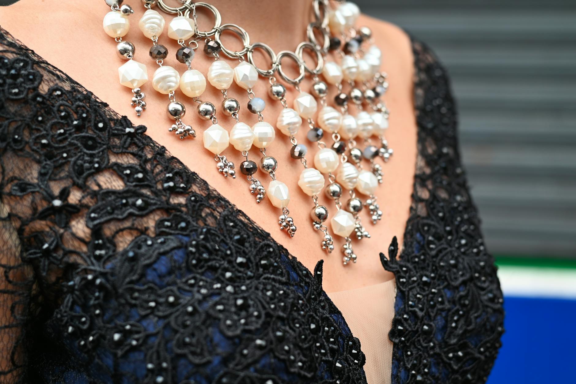 Naszyjnik z pereł na czarnej koronkowej sukience w stylu glamour