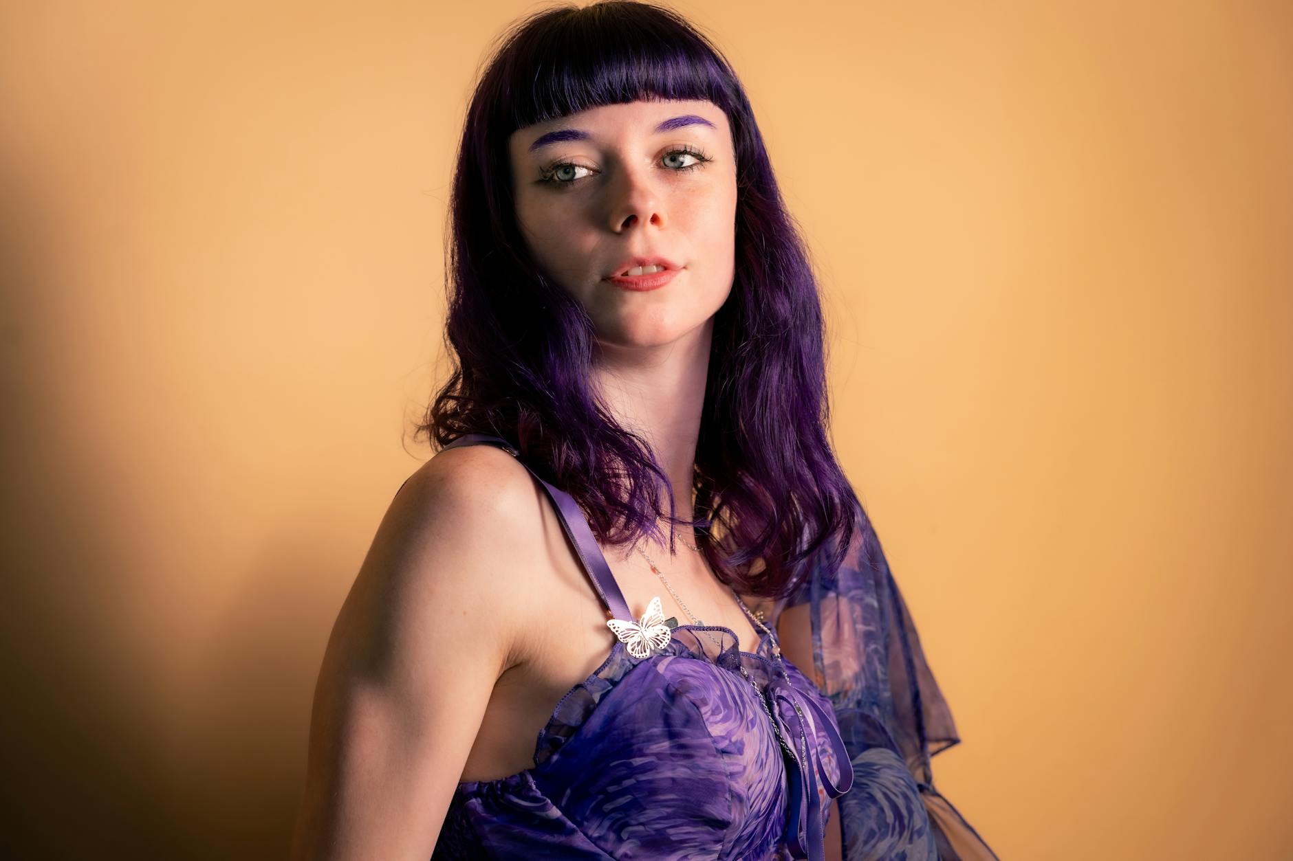 Portret kobiety o fioletowych włosach w eleganckiej sukni