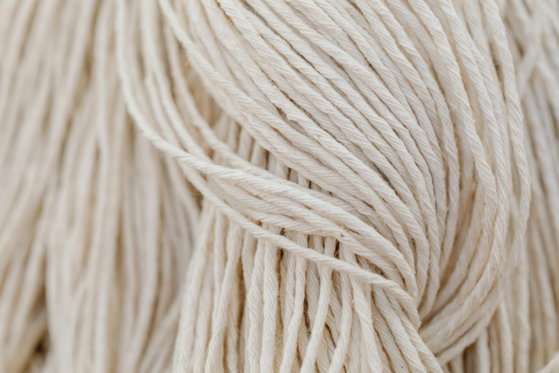 Splątane białe sznurki przypominające makramę do tworzenia bransoletek