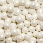 Perła w biżuterii: jak rozpoznać naturalną i jak o nią dbać na co dzień Zbliżenie na lśniące białe perły z widoczną gładką fakturą