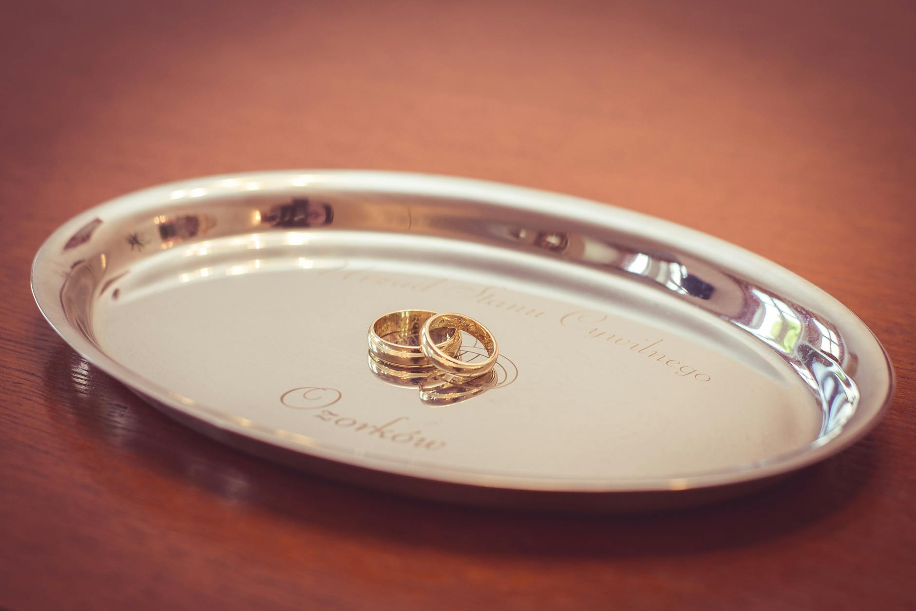 Złote obrączki ślubne na grawerowanej srebrnej tacy