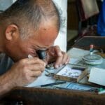 Jak rozpoznać dobrze wykonaną biżuterię? Detale, na które patrzy jubiler Jubiler z lupą dokładnie ogląda detale złotej biżuterii