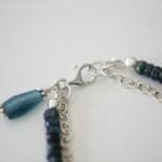 Czy srebro 925 może być ekologiczne? O pochodzeniu metalu i dodatkach stopowych Zbliżenie zapięcia srebrnego naszyjnika 925 z niebieskimi koralikami